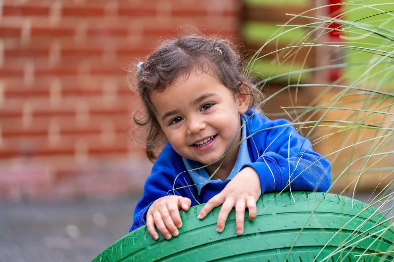 Public-facing version of the same outdoor play photo with the setting preserved and the pupil anonymised.